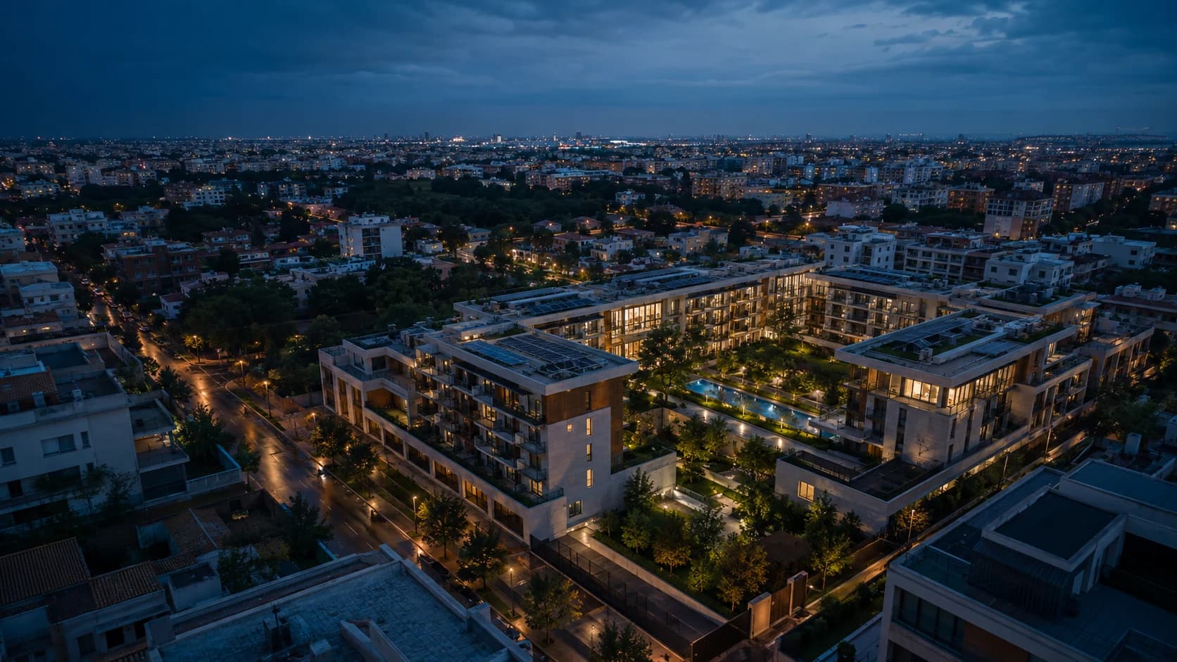 Vista aérea nocturna de una comunidad residencial moderna con zonas comunes